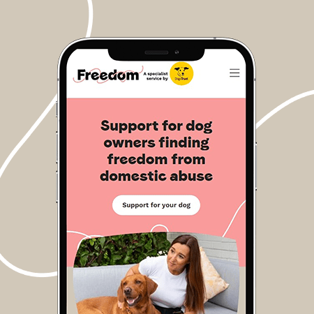 Phone showing responsive charity web design with wording Support for dog owners finding freedom from domestic abuse
