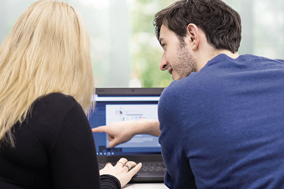 Two people at a laptop editing a charity website
